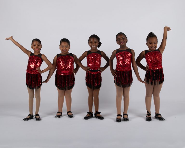 A group of young dancers posing for a photo during their dance class.