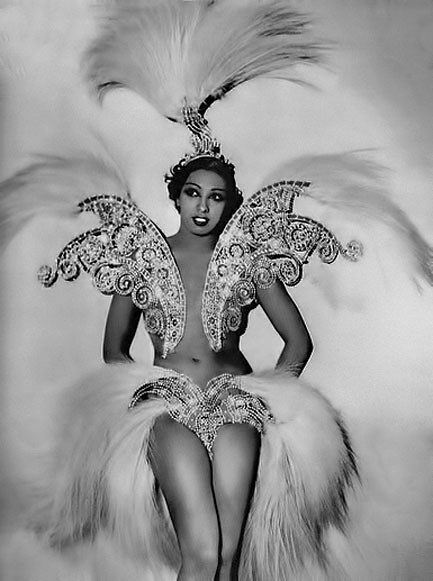 A black and white photo of a woman in a feathered costume.