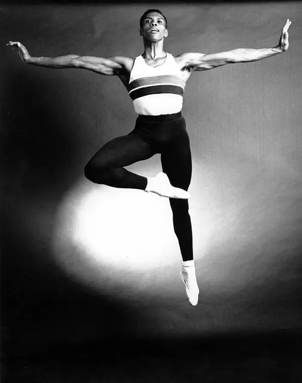 A black and white photo of a male ballet dancer.